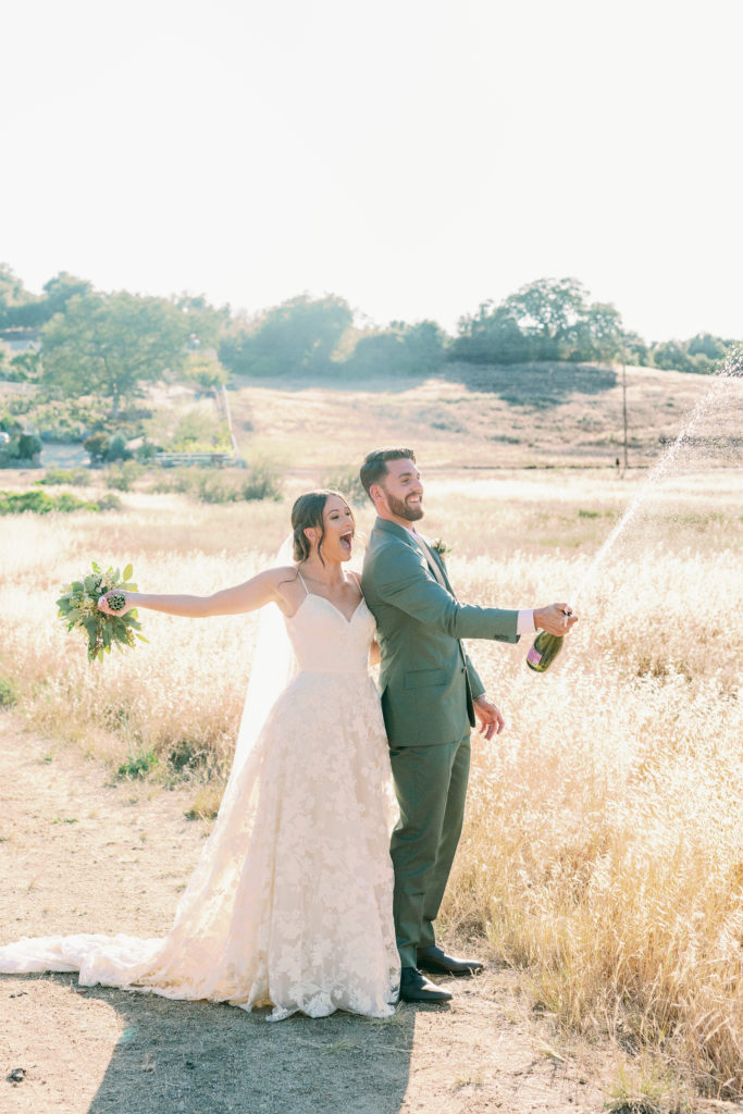 bride and groom popping champagne in temecula California at forever and always farm