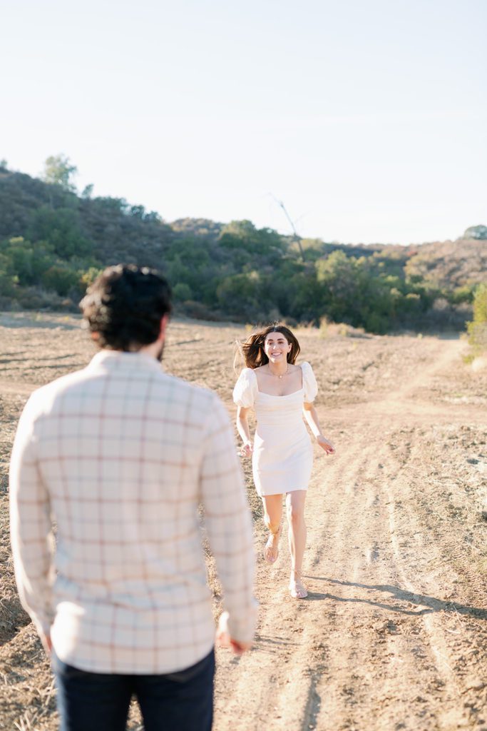 girl running at fiance engagement photos 